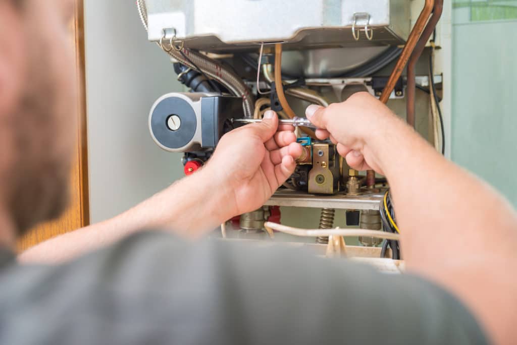 Trusted HVAC tech performing furnace installation